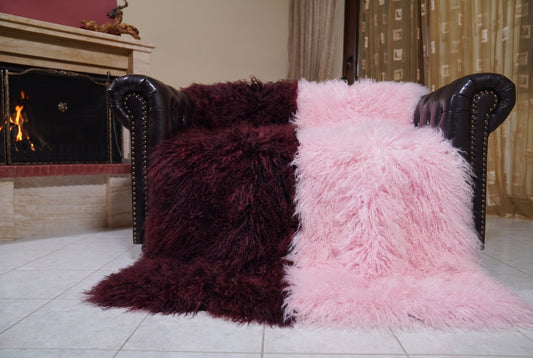 Mongolian Blanket Throw Dark Burgundy Pink Two Tone — Wool Sheepskin spread across the leather sofa showing the whole deep burgundy and powder pink Mongolian wool surface — Greek craftsmanship, TatiFurs