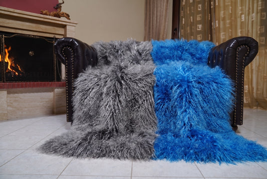 Mongolian Blanket Throw Grey Blue Two Tone — Wool Sheepskin spread across the leather sofa showing the whole charcoal grey and cobalt blue Mongolian wool surface — Greek craftsmanship, TatiFurs