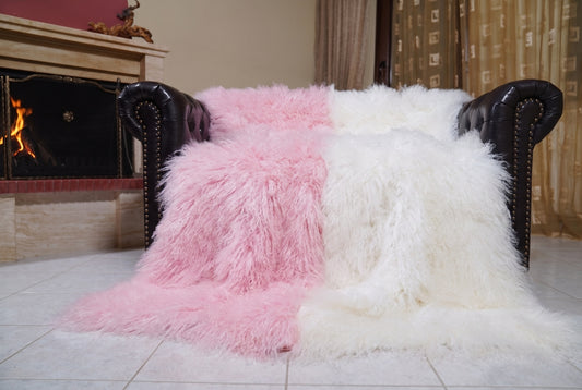 Mongolian Blanket Throw Pink White Two Tone — Wool Sheepskin spread across the leather sofa showing the whole powder pink and pure white Mongolian wool surface — Greek craftsmanship, TatiFurs