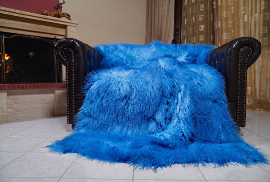 Mongolian Blanket Throw Blue — Wool Sheepskin Full Skin spread across the leather sofa showing the whole vivid cobalt blue Mongolian wool surface — Greek craftsmanship, TatiFurs