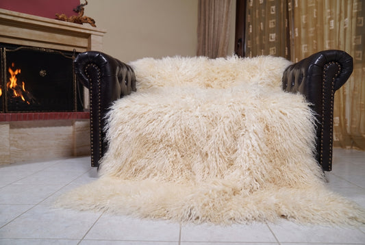 Mongolian Blanket Throw Cream — Wool Sheepskin Full Skin spread across the leather sofa showing the whole soft ivory cream Mongolian wool surface — Greek craftsmanship, TatiFurs