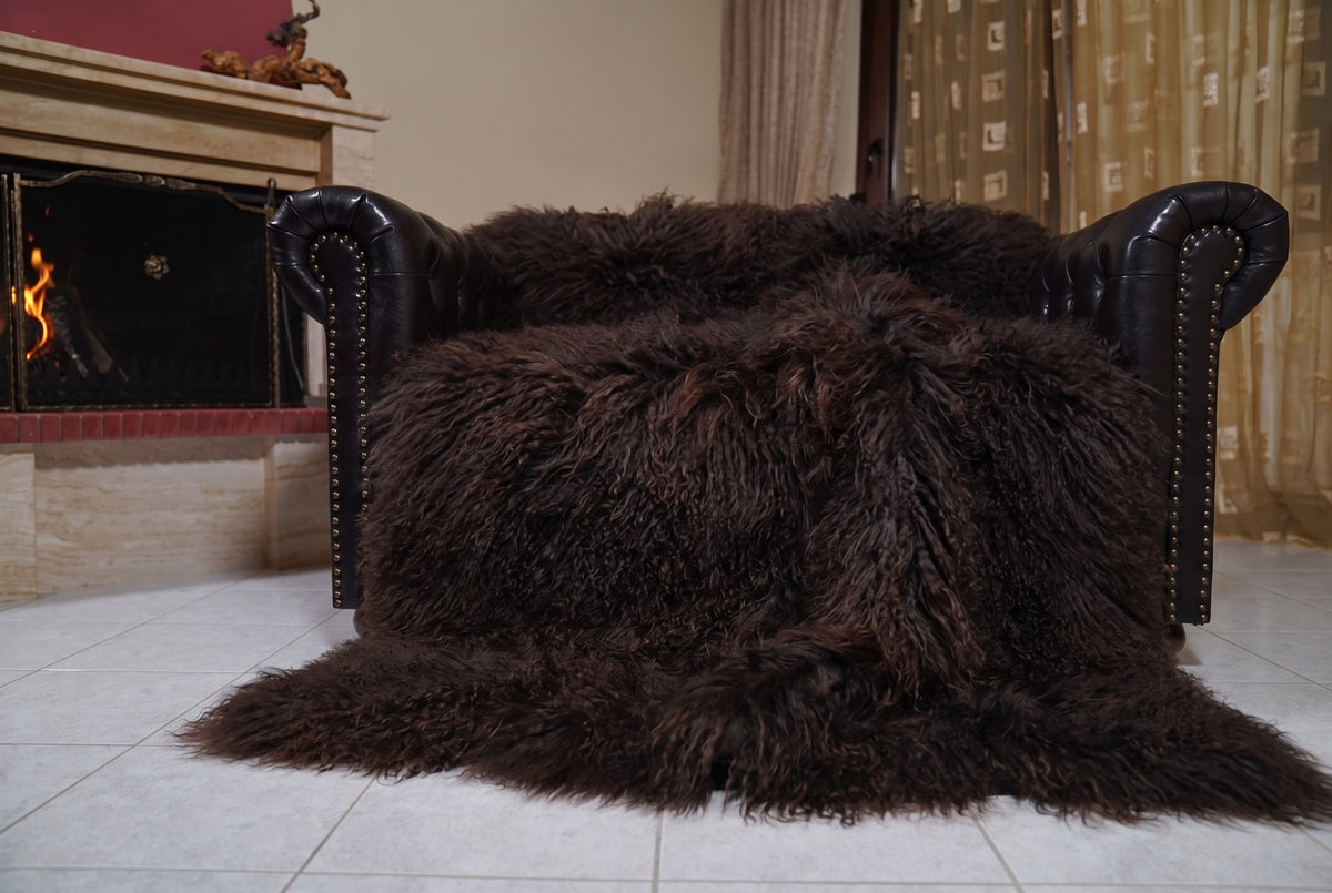Mongolian Blanket Throw Dark Brown — Wool Sheepskin Full Skin spread across the leather sofa showing the whole deep espresso dark brown Mongolian wool surface — Greek craftsmanship, TatiFurs