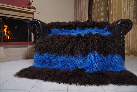 Mongolian Blanket Throw Blue Dark Brown Striped — Wool Sheepskin spread across the leather sofa showing the whole cobalt blue and espresso brown Mongolian wool surface — Greek craftsmanship, TatiFurs