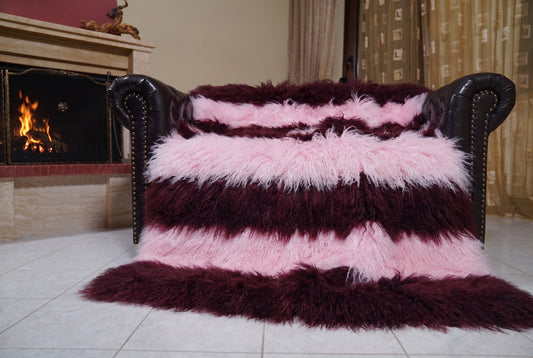 Mongolian Blanket Throw Dark Burgundy Pink Striped — Wool Sheepskin spread across the leather sofa showing the whole deep burgundy and powder pink Mongolian wool surface — Greek craftsmanship, TatiFurs