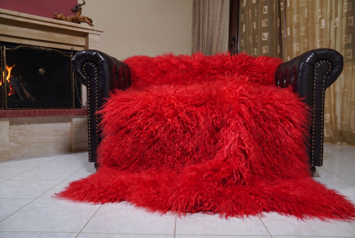 Mongolian Blanket Throw Red — Wool Sheepskin Full Skin spread across the leather sofa showing the whole vivid scarlet red Mongolian wool surface — Greek craftsmanship, TatiFurs