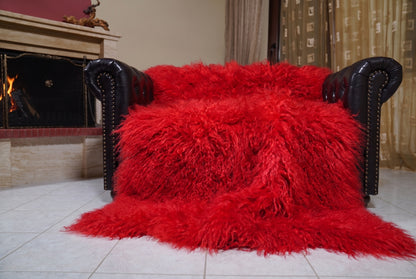 Mongolian Blanket Throw Red — Wool Sheepskin Full Skin spread across the leather sofa showing the whole vivid scarlet red Mongolian wool surface — Greek craftsmanship, TatiFurs