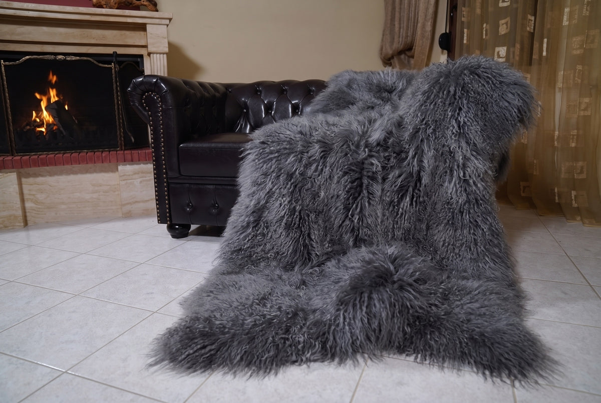 Mongolian Blanket Throw Gray — Wool Sheepskin Full Skin draped from the sofa towards the fireplace showing how the grey long wool falls — TatiFurs