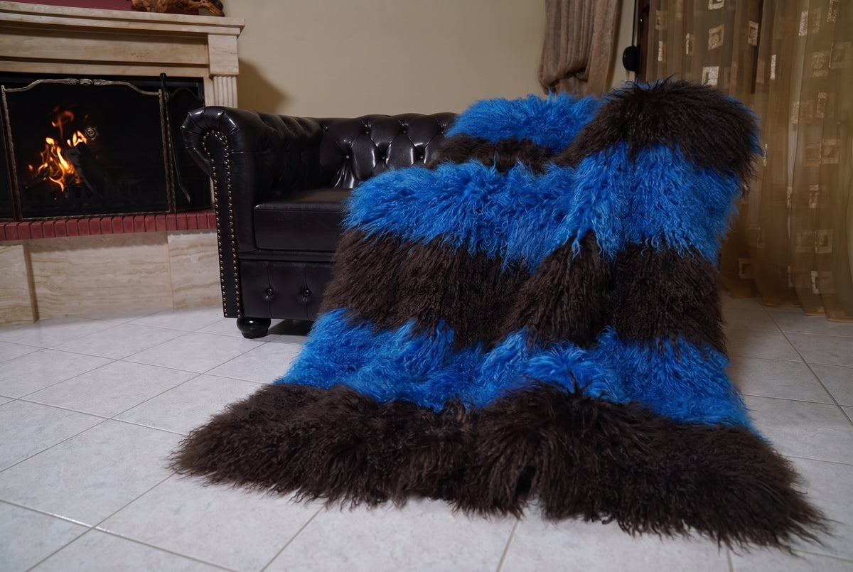Mongolian Blanket Throw Blue Dark Brown Striped — Wool Sheepskin draped from the sofa towards the fireplace showing how the cobalt blue and espresso brown long wool falls — TatiFurs