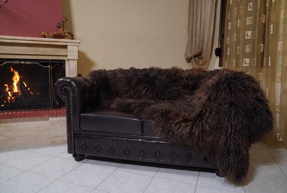Mongolian Blanket Throw Dark Brown — Wool Sheepskin Full Skin hanging from the sofa down to the travertine floor — deep espresso dark brown Mongolian sheepskin throw, TatiFurs