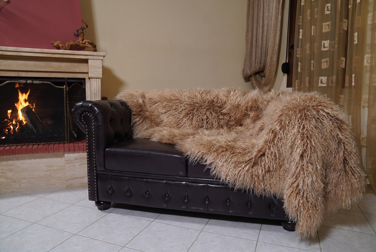 Mongolian Blanket Throw Light Brown — Wool Sheepskin Full Skin hanging from the sofa down to the travertine floor — milky caramel light brown Mongolian sheepskin throw, TatiFurs