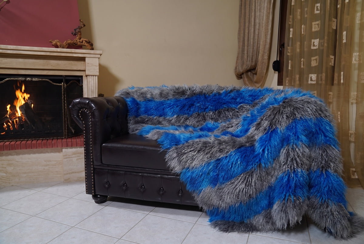 Mongolian Blanket Throw Grey Blue Striped — Wool Sheepskin hanging from the sofa down to the travertine floor — charcoal grey and cobalt blue Mongolian sheepskin throw, TatiFurs
