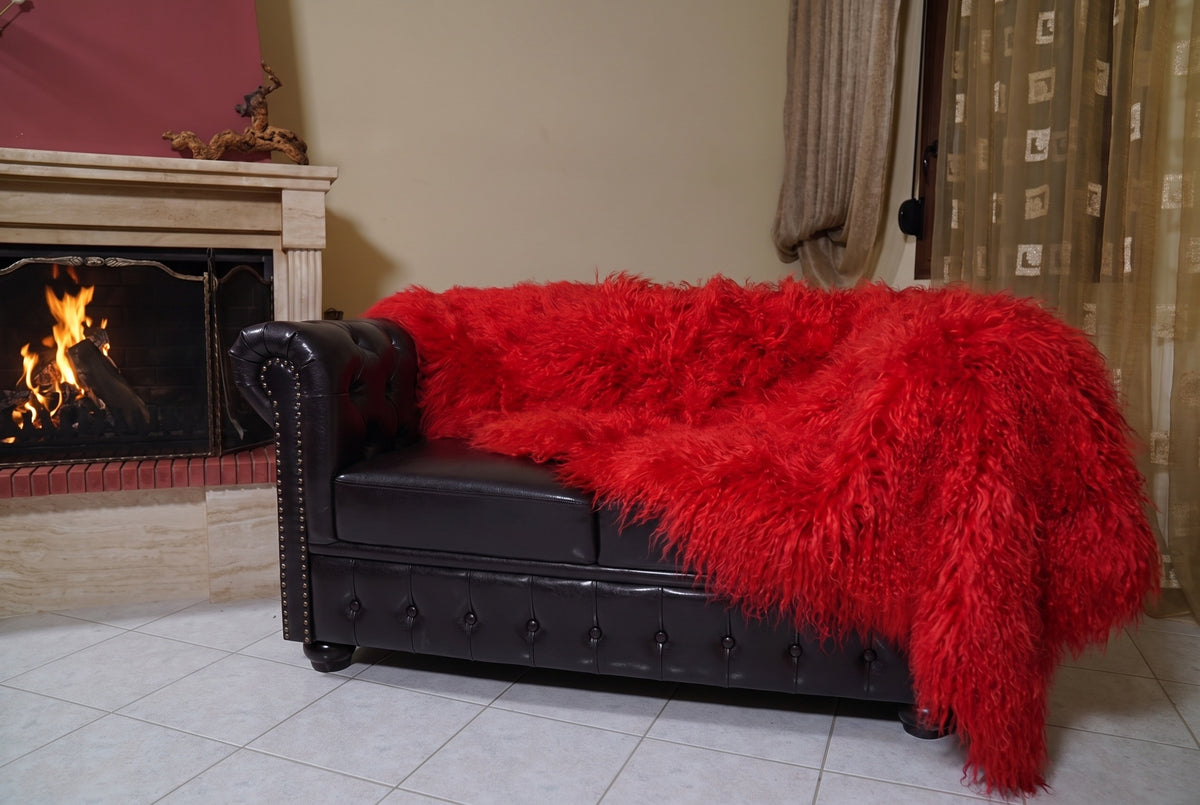 Mongolian Blanket Throw Red — Wool Sheepskin Full Skin hanging from the sofa down to the travertine floor — vivid scarlet red Mongolian sheepskin throw, TatiFurs