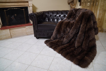 Fox Fur Blanket Throw Dark Brown — Full Skin Saga Furs spilling from the armchair onto the tiled floor — the deep chocolate brown full skin fox fur catching the light, TatiFurs