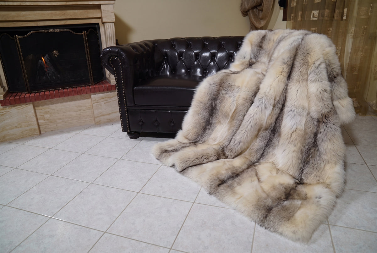 Fox Fur Blanket Throw Fawn Light — Full Skin Saga Furs spilling from the armchair onto the tiled floor — the light fawn with a soft grey-brown line full skin fox fur catching the light, TatiFurs