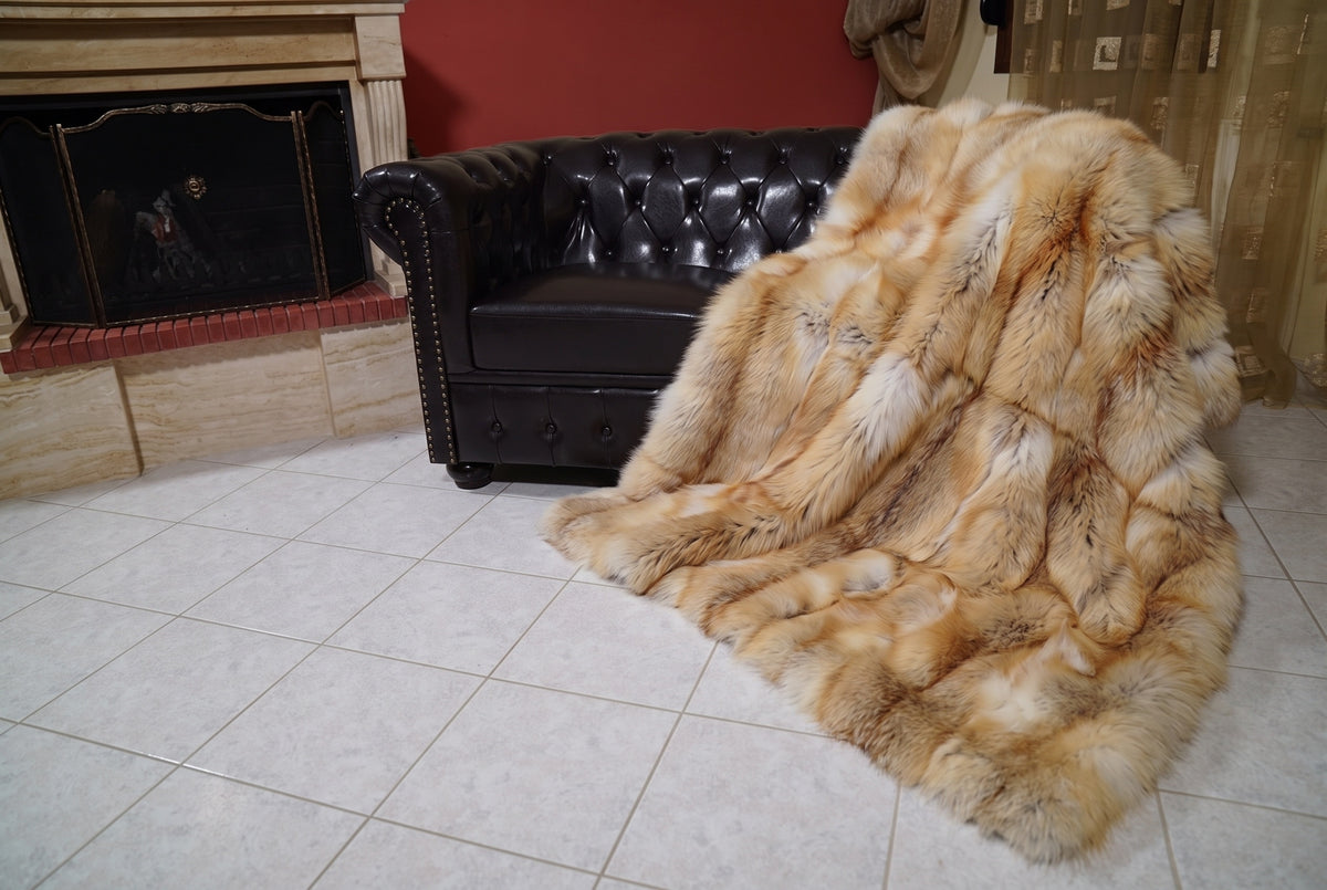 Fox Fur Blanket Throw Golden Island — Full Skin Saga Furs spilling from the armchair onto the tiled floor — the honey-gold Golden Island full skin fox fur catching the light, TatiFurs