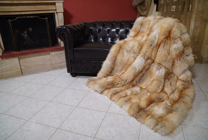Fox Fur Blanket Throw Golden Island — Full Skin Saga Furs spilling from the armchair onto the tiled floor — the honey-gold Golden Island full skin fox fur catching the light, TatiFurs