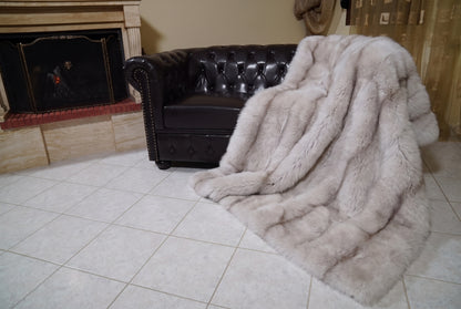 Fox Fur Blanket Throw Pastel Frost — Full Skin Saga Furs spilling from the armchair onto the tiled floor — the soft greige with a taupe line full skin fox fur catching the light, TatiFurs