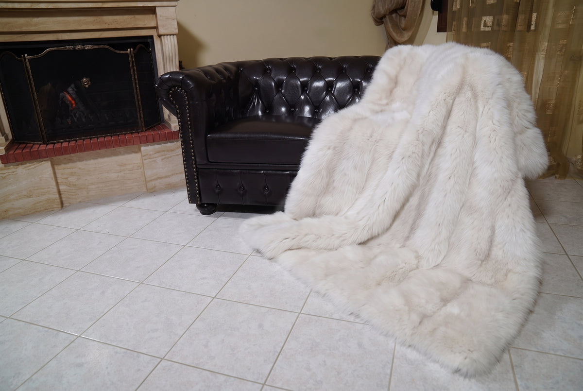 Fox Fur Blanket Throw Pearl Frost — Full Skin Saga Furs spilling from the armchair onto the tiled floor — the pearl ivory with a soft champagne glow full skin fox fur catching the light, TatiFurs