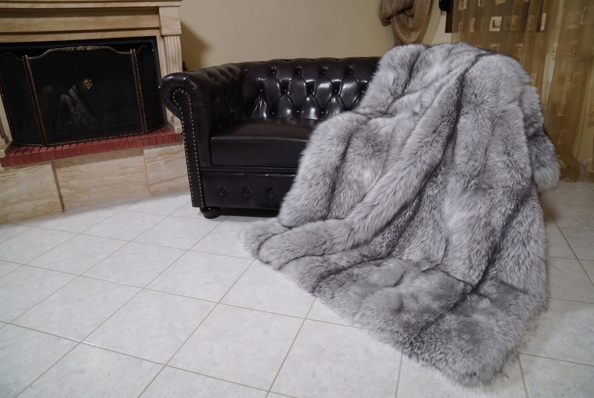 Fox Fur Blanket Throw Sapphire Frost — Full Skin Saga Furs spilling from the armchair onto the tiled floor — the silver grey with white frosted tips and a charcoal line full skin fox fur catching the light, TatiFurs