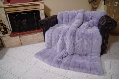 Fox Fur Blanket Throw Lavender Purple — Full Skin Saga Furs covering the back and seat of the leather armchair, fireplace behind — the soft lavender purple fox skins worked head to tail, TatiFurs