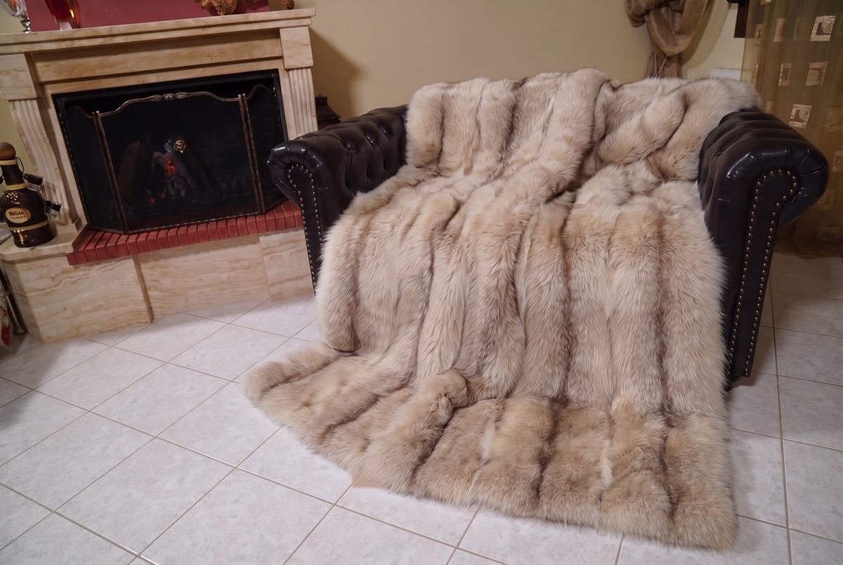 Fox Fur Blanket Throw Palomino Frost — Full Skin Saga Furs covering the back and seat of the leather armchair, fireplace behind — the sand and brown Palomino Frost fox skins worked head to tail, TatiFurs