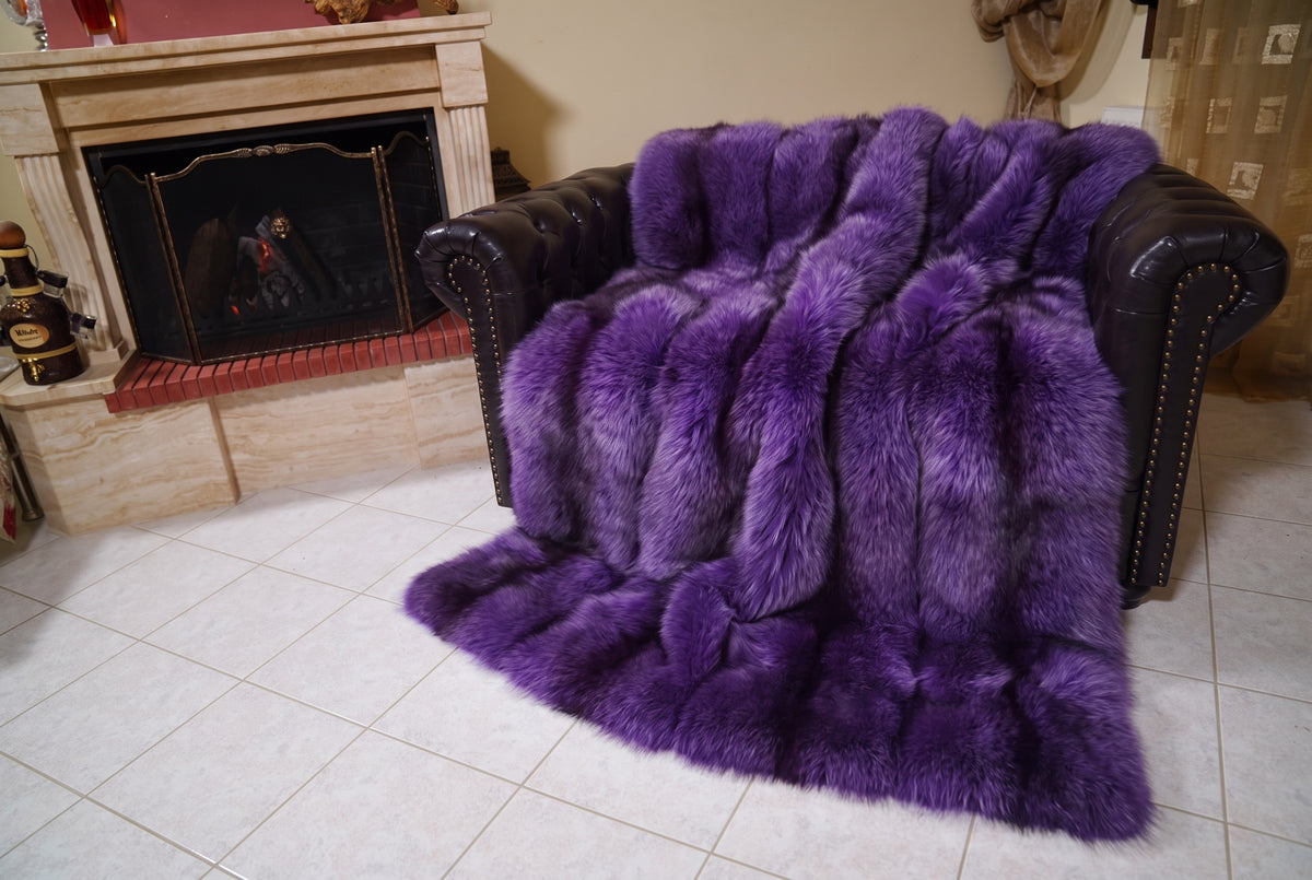 Fox Fur Blanket Throw Purple — Full Skin Saga Furs covering the back and seat of the leather armchair, fireplace behind — the rich violet purple fox skins worked head to tail, TatiFurs