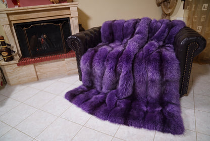 Fox Fur Blanket Throw Purple — Full Skin Saga Furs covering the back and seat of the leather armchair, fireplace behind — the rich violet purple fox skins worked head to tail, TatiFurs