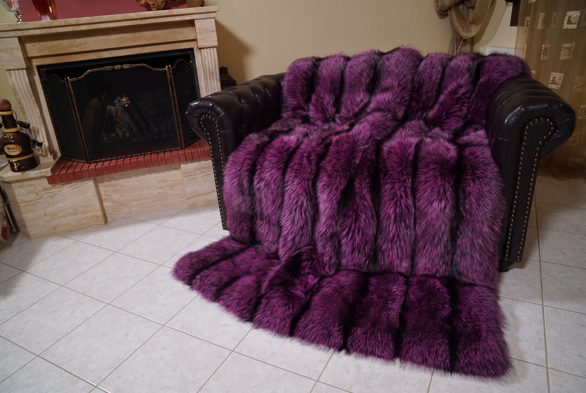 Fox Fur Blanket Throw Purple Silver — Full Skin Saga Furs covering the back and seat of the leather armchair, fireplace behind — the purple-tipped silver fox skins worked head to tail, TatiFurs