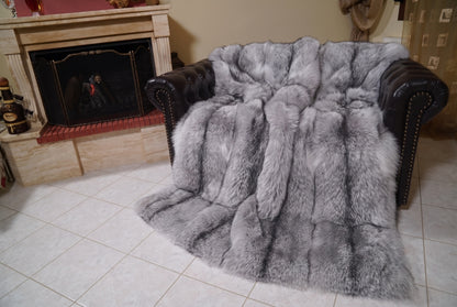 Fox Fur Blanket Throw Sapphire Frost — Full Skin Saga Furs covering the back and seat of the leather armchair, fireplace behind — the silver grey with white frosted tips and a charcoal line fox skins worked head to tail, TatiFurs