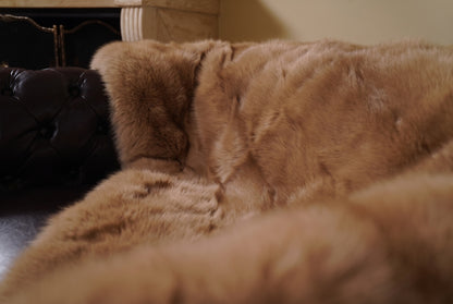 Fox Fur Blanket Throw Camel Brown — Full Skin Saga Furs close-up of the dense warm golden camel brown fox fur texture at the edge of the armchair — Saga Furs quality, TatiFurs