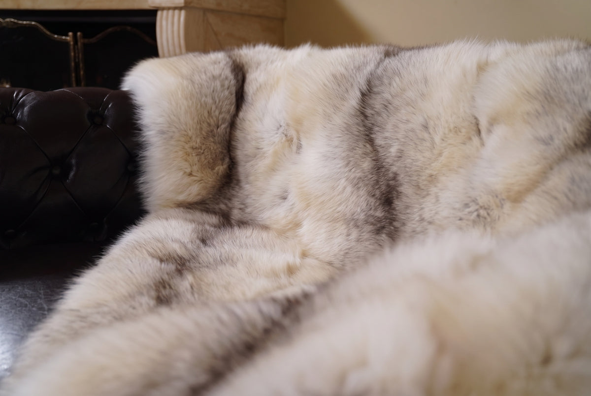 Fox Fur Blanket Throw Fawn Light — Full Skin Saga Furs close-up of the dense light fawn with a soft grey-brown line fox fur texture at the edge of the armchair — Saga Furs quality, TatiFurs