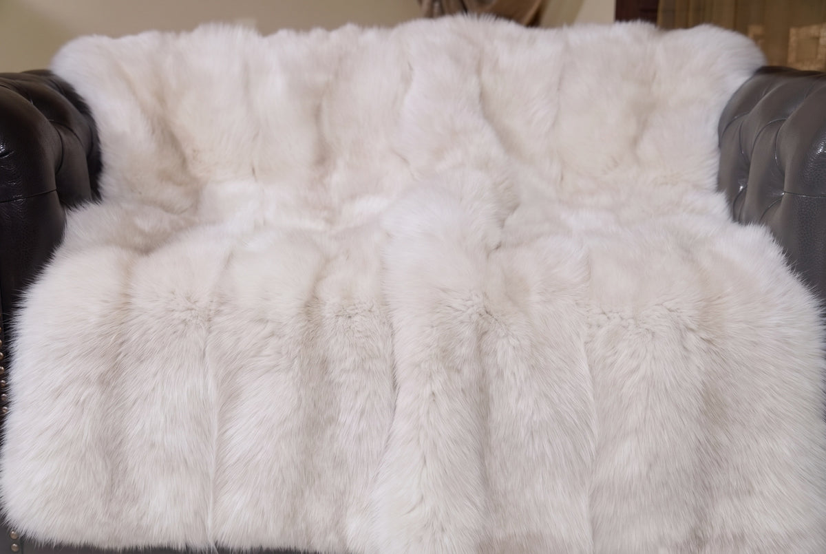 Fox Fur Blanket Throw Pearl Frost — Full Skin Saga Furs close-up of the dense pearl ivory with a soft champagne glow fox fur texture at the edge of the armchair — Saga Furs quality, TatiFurs