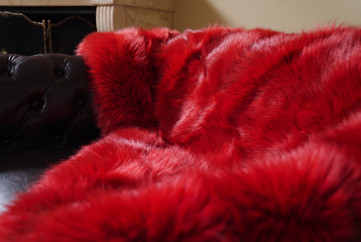Fox Fur Blanket Throw Red — Full Skin Saga Furs close-up of the dense vivid scarlet red fox fur texture at the edge of the armchair — Saga Furs quality, TatiFurs