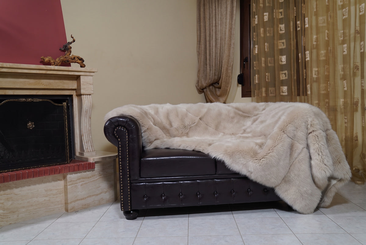 Fox Fur Blanket Throw Beige — Full Skin Saga Furs on the leather armchair in a fireplace living room with curtains — warm sand beige real fox fur throw, TatiFurs