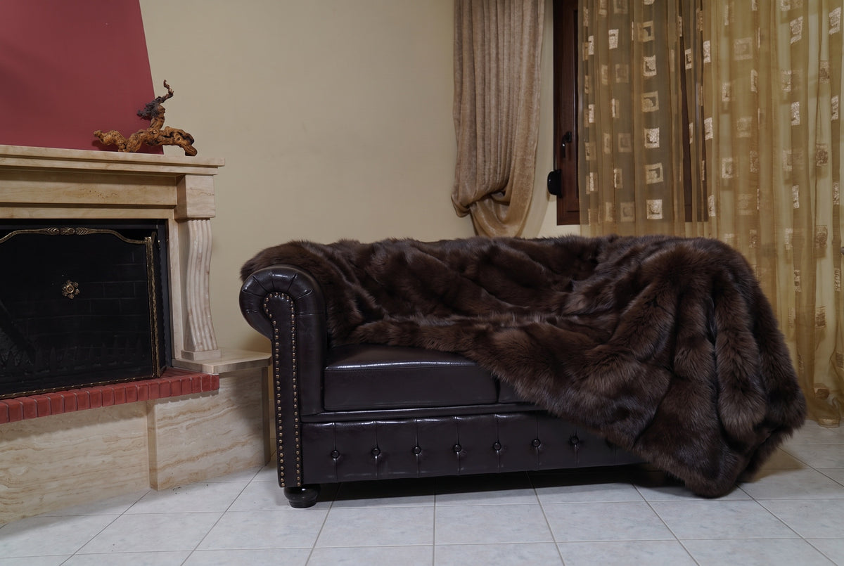 Fox Fur Blanket Throw Dark Brown — Full Skin Saga Furs on the leather armchair in a fireplace living room with curtains — deep chocolate brown real fox fur throw, TatiFurs
