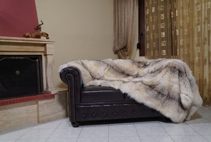 Fox Fur Blanket Throw Fawn Light — Full Skin Saga Furs on the leather armchair in a fireplace living room with curtains — light fawn with a soft grey-brown line real fox fur throw, TatiFurs