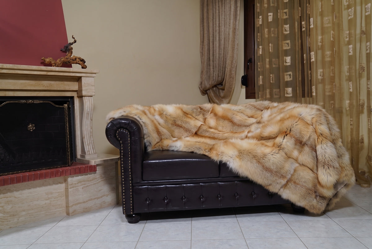 Fox Fur Blanket Throw Golden Island — Full Skin Saga Furs on the leather armchair in a fireplace living room with curtains — honey-gold Golden Island real fox fur throw, TatiFurs