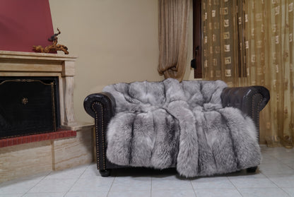 Fox Fur Blanket Throw Sapphire Frost — Full Skin Saga Furs on the leather armchair in a fireplace living room with curtains — silver grey with white frosted tips and a charcoal line real fox fur throw, TatiFurs