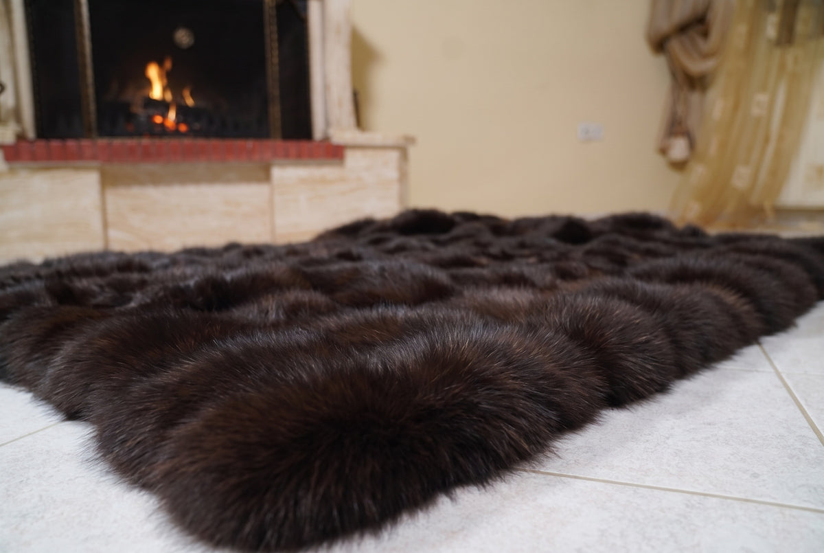 Fox Fur Blanket Throw Dark Brown — Full Skin Saga Furs laid flat on the floor in front of the lit fireplace, low angle showing the deep chocolate brown fox pelt rows, TatiFurs