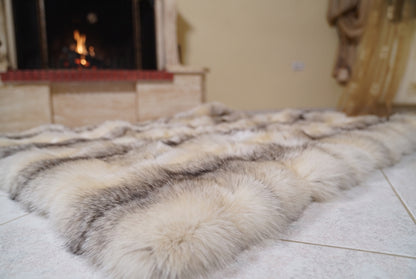 Fox Fur Blanket Throw Fawn Light — Full Skin Saga Furs laid flat on the floor in front of the lit fireplace, low angle showing the light fawn with a soft grey-brown line fox pelt rows, TatiFurs