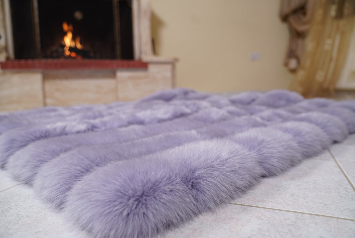Fox Fur Blanket Throw Lavender Purple — Full Skin Saga Furs laid flat on the floor in front of the lit fireplace, low angle showing the soft lavender purple fox pelt rows, TatiFurs