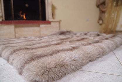 Fox Fur Blanket Throw Palomino Frost — Full Skin Saga Furs laid flat on the floor in front of the lit fireplace, low angle showing the sand and brown Palomino Frost fox pelt rows, TatiFurs