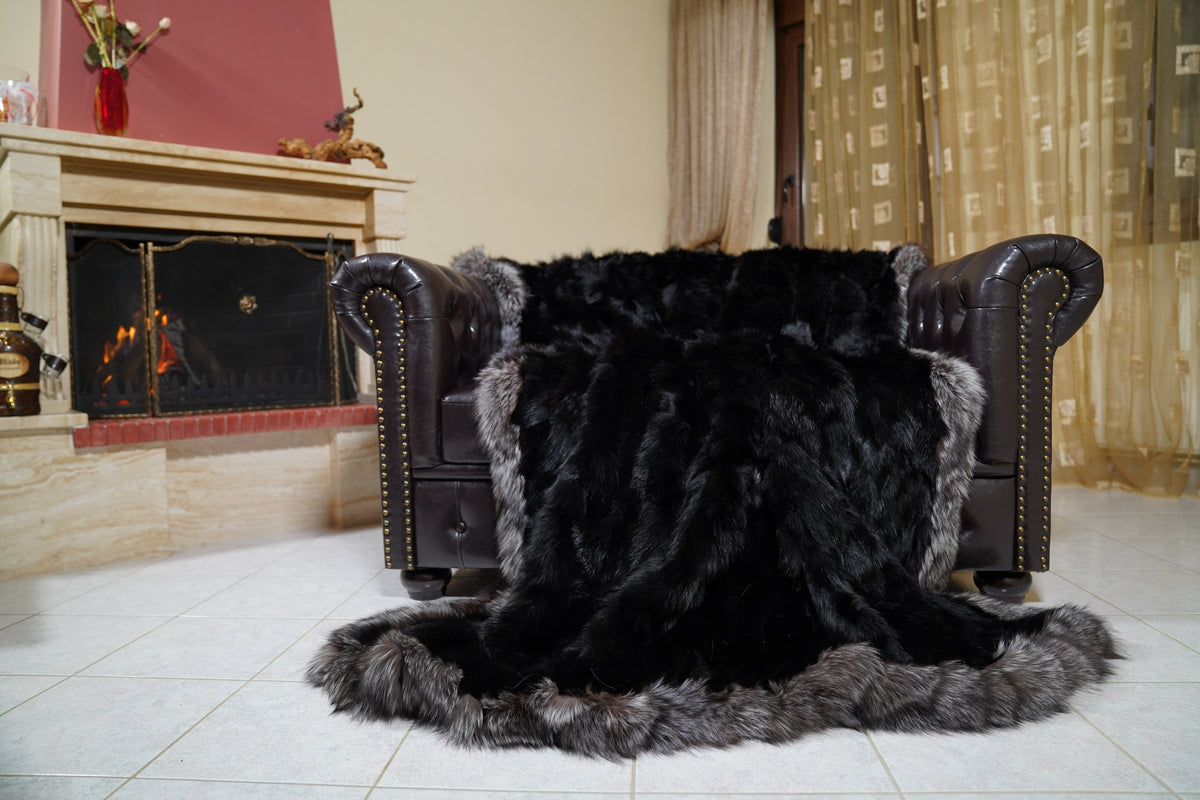 fox fur blanket throw black silver borders — full view draped over a leather sofa, dyed black fox centre framed by silver fox borders — TatiFurs