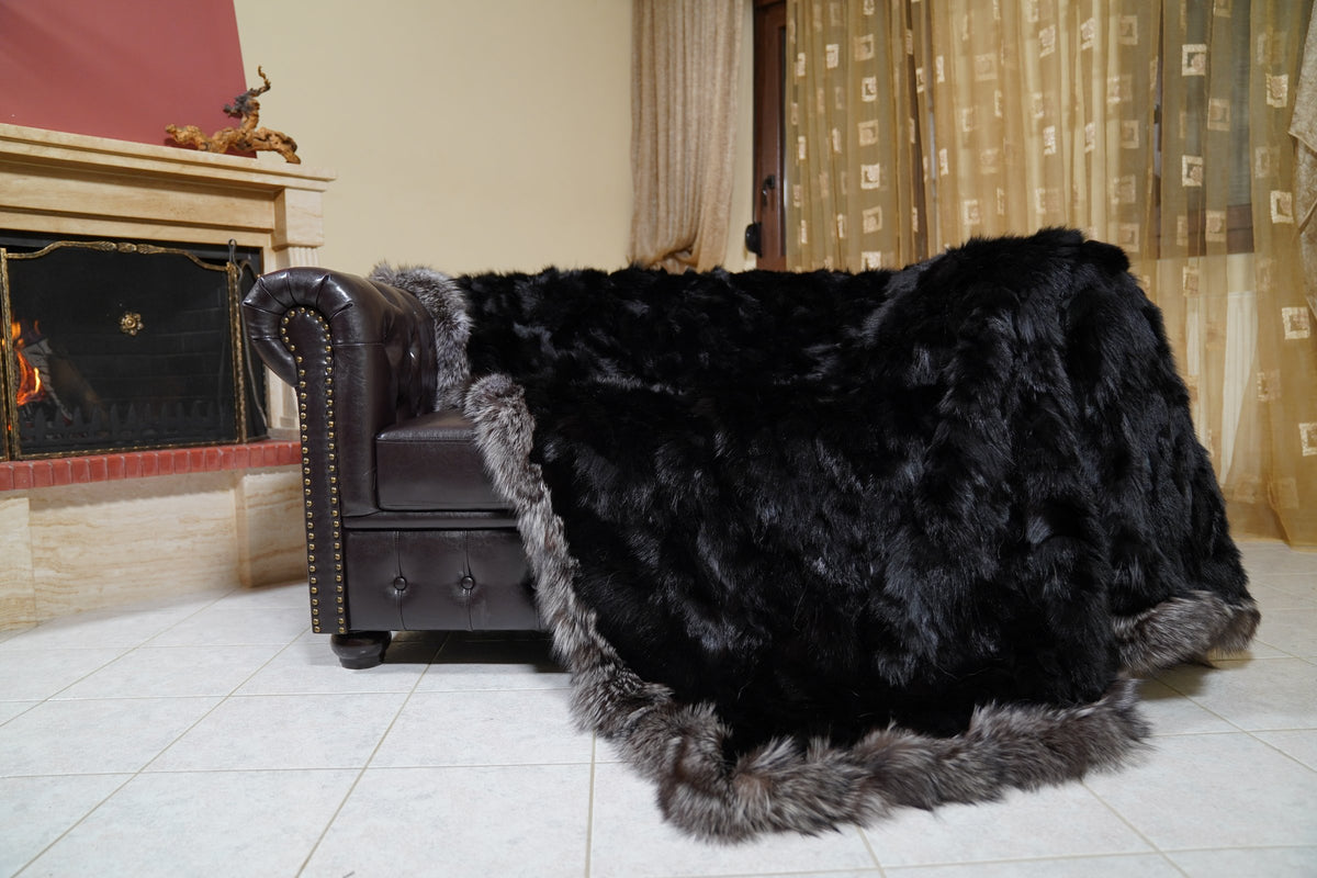 fox fur blanket throw black silver borders — draped across a Chesterfield sofa by the fireplace, long black fox pile and silver edges — Greek craftsmanship, TatiFurs