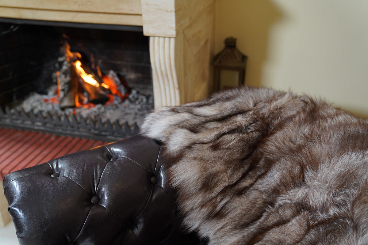 fox fur blanket throw crystal natural striped — close-up of the natural crystal fox fur by the fireplace, silver tips over brown and black — TatiFurs