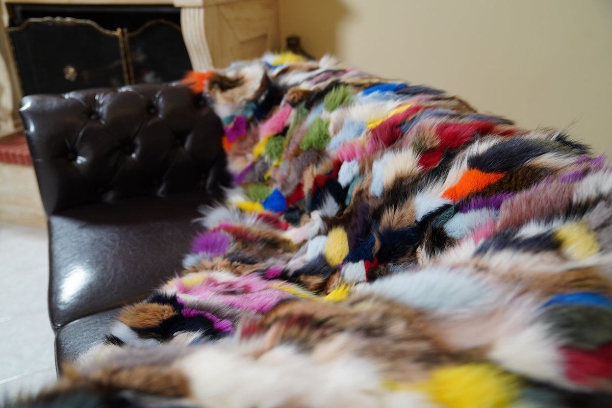 fox fur blanket throw double sided colorful — detail over the sofa arm, pink, green, yellow and blue fox panels — TatiFurs