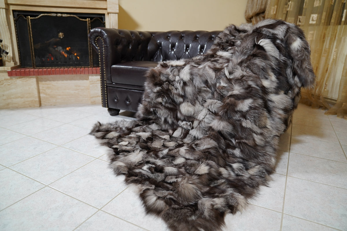 fox fur blanket throw double sided frost natural — full view draped over a Chesterfield sofa by the fireplace, natural silver, brown and black frost fox — TatiFurs