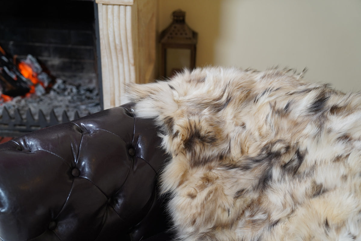 fox fur blanket throw iceberg beige natural — close-up of the natural iceberg beige fox fur by the fireplace — TatiFurs