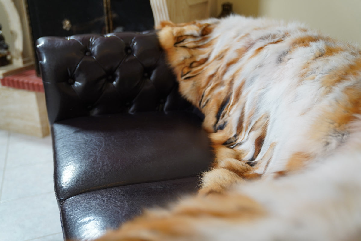 fox fur blanket throw red canadian striped — detail over the sofa arm, orange-red fox rows and white fox stripes — TatiFurs