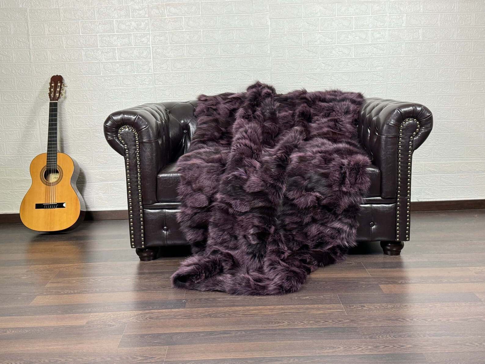 Fox fur throw blanket in purple with black details shown in natural light revealing depth and striking contrast
